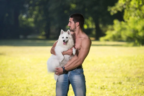 Sexig Man håller hund tysk Spitz i Park — Stockfoto