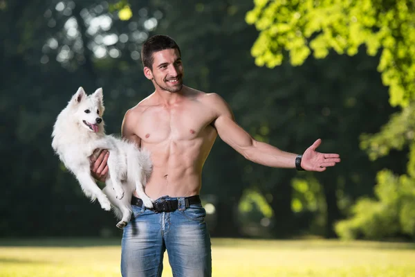 Sexy Man Holding Dog German Spitz In Park