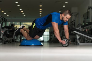 Bosu denge Ball egzersiz yapan genç erkek