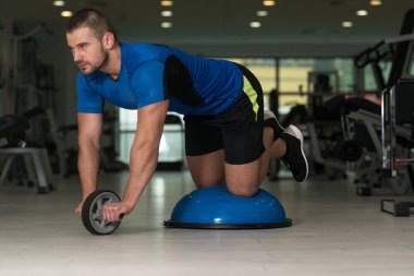 Bosu denge Ball egzersiz yapan genç erkek