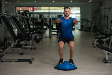 Bosu denge Ball egzersiz yapan genç erkek