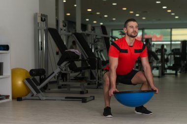 Bosu denge Ball egzersiz yapan genç erkek