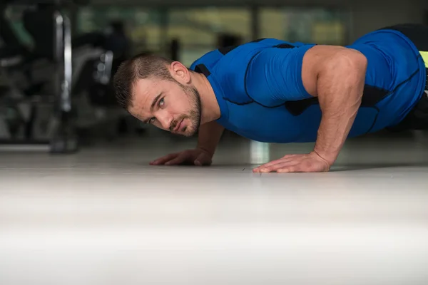 Entrenador personal haciendo flexiones en el piso — Foto de Stock