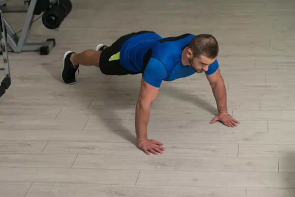 Atleta hombre haciendo push ups en el piso — Foto de Stock