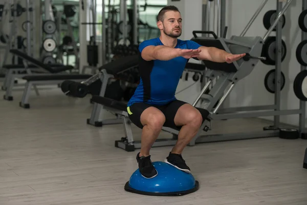 Junger Mann turnt auf Bosu-Balance-Ball — Stockfoto