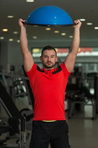 Hombre joven haciendo ejercicio en Bosu Balance Ball — Foto de Stock