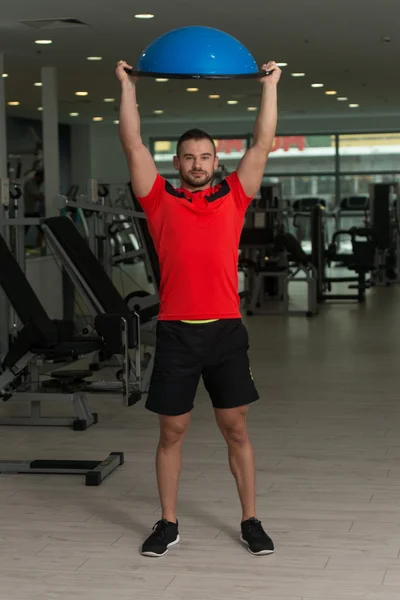 Hombre joven haciendo ejercicio en Bosu Balance Ball — Foto de Stock