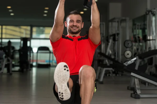 Giovane attraente uomo formazione con cinghie di fitness Trx — Foto Stock