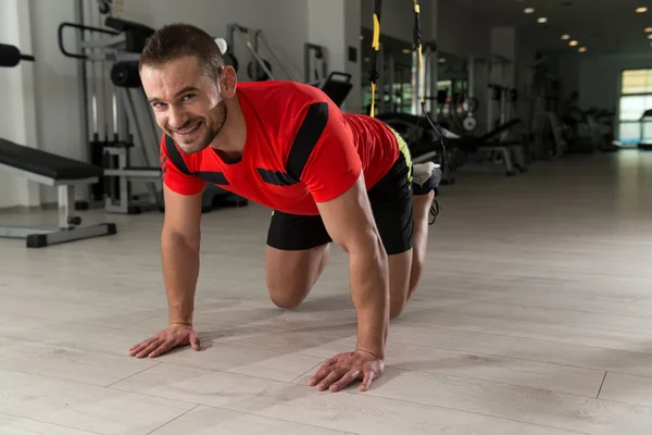 Junger attraktiver Mann trainiert mit trx Fitnessbändern — Stockfoto