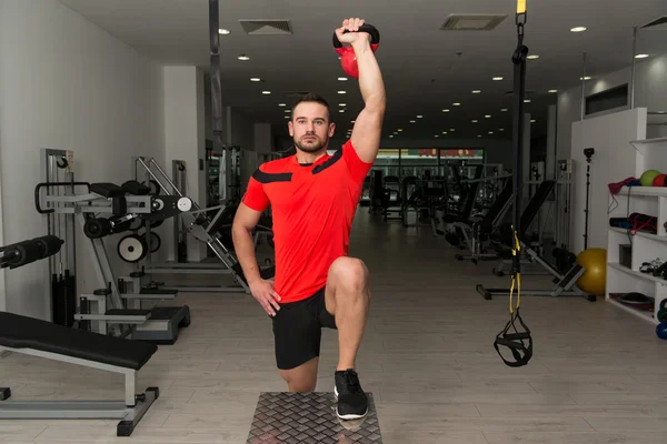 Istruttore di fitness che fa esercizio fisico pesante con bollitore-campana — Foto Stock