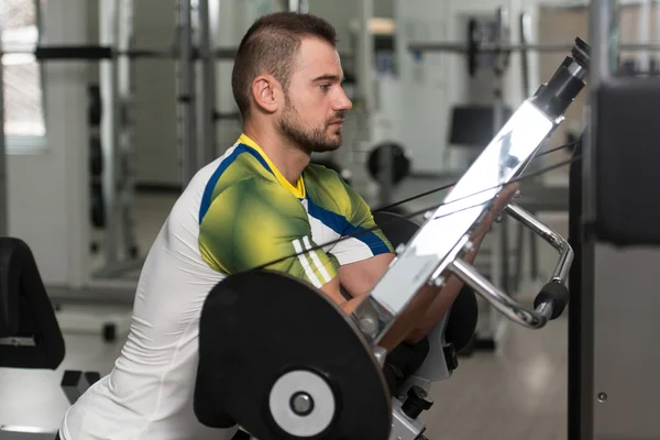 Hombre entrenamiento bíceps ejercicios en una máquina —  Fotos de Stock