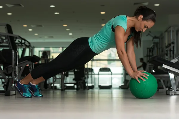 Donna attraente che fa flessioni sul pavimento in palestra — Foto Stock