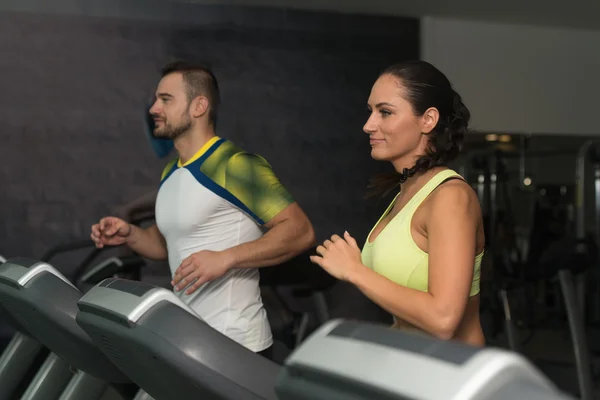 Groep van mensen lopen op de loopband in de sportschool — Stockfoto