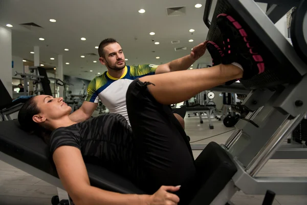 Treinador de ginástica ajudando mulher em pernas — Fotografia de Stock