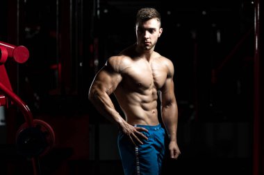 Spor Salonunda Güçlü Duran Genç Adam - Kas Atletik Vücut Geliştirici Spor Sonrası Spor Pozisyonu