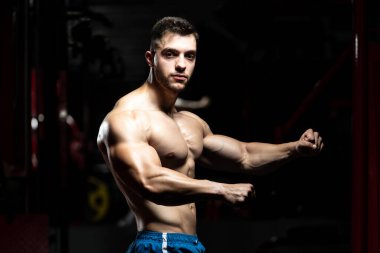 Spor Salonunda Güçlü Duran Genç Adam - Kas Atletik Vücut Geliştirici Spor Sonrası Spor Pozisyonu