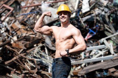 Hurdalıkta Güçlü Duran Yakışıklı Adam Endüstriyel Hurdalıkta ve Esnek Kaslarda - Kaslı Atletik Vücut Geliştirici Sarı Miğferli Fitness Pozisyonu