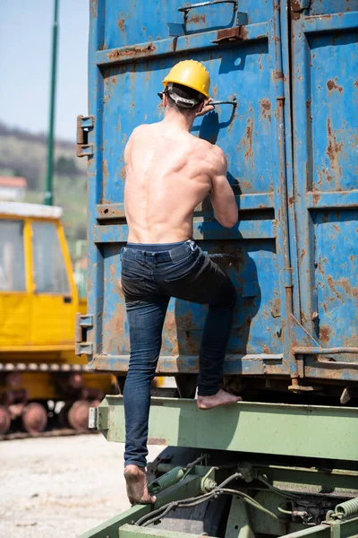 Junger Mann Klettert Industriegebiet Auf Anhänger Und Trägt Gelben Helm — Stockfoto