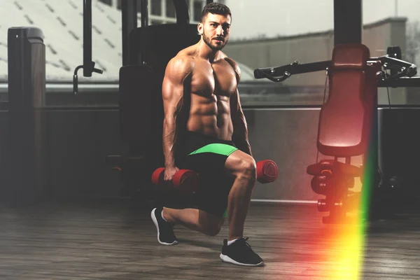 Spor Salonundaki Güçlü Adam Dambıllarla Bacak Egzersizi Yapıyor Kaslı Atletik — Stok fotoğraf