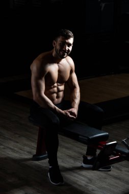 Yakışıklı ve çekici bir genç adam. Vücut kasları spor salonunda dinleniyor.
