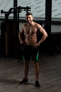 İyi eğitilmiş vücudunu gösteren genç bir adamın portresi - kaslı atletik vücut geliştirici spor sonrası vücut geliştirme modelliği pozu