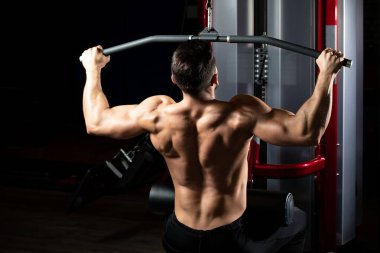 Yakışıklı Vücut Geliştirici Makineye Geri Dönmek İçin Ağır Ağırlık Egzersizi Yapıyor