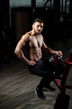 Yakışıklı ve çekici bir genç adam. Vücut kasları spor salonunda dinleniyor.