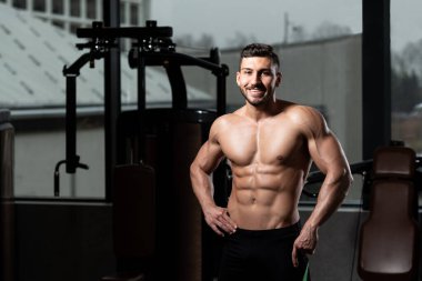 İyi eğitilmiş vücudunu gösteren genç bir adamın portresi - kaslı atletik vücut geliştirici spor sonrası vücut geliştirme modelliği pozu