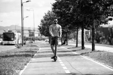 Scooter 'a binen genç adam Şehrin caddesi boyunca