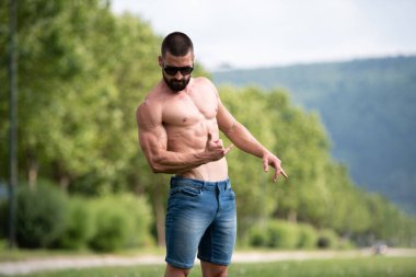 Yakışıklı Sakallı Adam Güçlü Duruyor ve Dışarda Pozisyon Veriyor Yaprakların Arkaplan Doğası