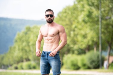 Yakışıklı Sakallı Adam Güçlü Duruyor ve Dışarda Pozisyon Veriyor Yaprakların Arkaplan Doğası