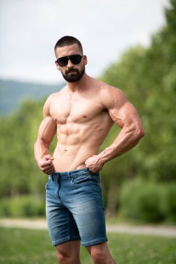 Yakışıklı Sakallı Adam Güçlü Duruyor ve Dışarda Pozisyon Veriyor Yaprakların Arkaplan Doğası