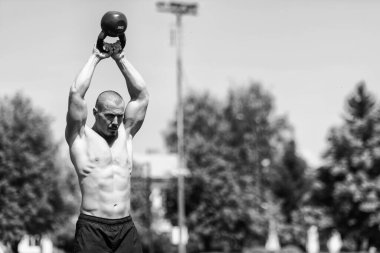 Kettle Bell 'le antrenman yapan adam vücut geliştirici. Kettle Bell' le ağırlık egzersizi yapıyor.