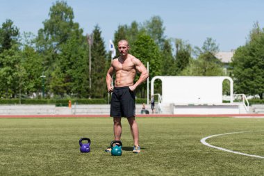 Kettle Bell 'le antrenman yapan adam vücut geliştirici. Kettle Bell' le ağırlık egzersizi yapıyor.