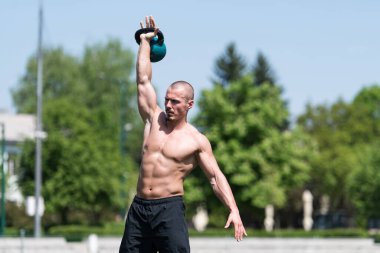 Kettle Bell 'le antrenman yapan adam vücut geliştirici. Kettle Bell' le ağırlık egzersizi yapıyor.