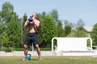 Kettle Bell 'le antrenman yapan adam vücut geliştirici. Kettle Bell' le ağırlık egzersizi yapıyor.