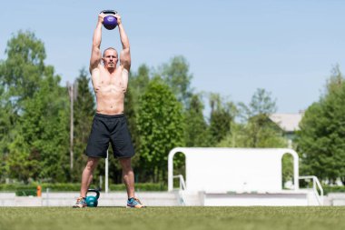 Kettle Bell 'le antrenman yapan adam vücut geliştirici. Kettle Bell' le ağırlık egzersizi yapıyor.