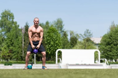 Kettle Bell 'le antrenman yapan adam vücut geliştirici. Kettle Bell' le ağırlık egzersizi yapıyor.