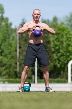 Kettle Bell 'le antrenman yapan adam vücut geliştirici. Kettle Bell' le ağırlık egzersizi yapıyor.