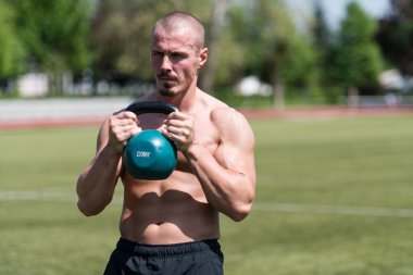 Kettle Bell 'le antrenman yapan adam vücut geliştirici. Kettle Bell' le ağırlık egzersizi yapıyor.
