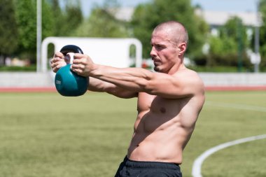 Kettle Bell 'le antrenman yapan adam vücut geliştirici. Kettle Bell' le ağırlık egzersizi yapıyor.