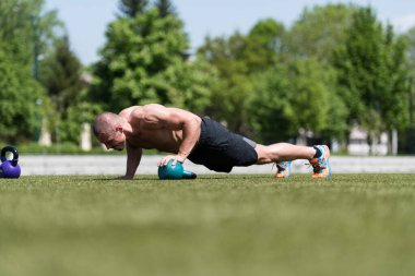 Kettle Bell 'le şınav çeken sağlıklı bir sporcu. Kettle-Bell Egzersizi.