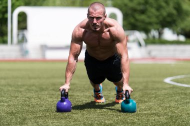 Kettle Bell 'le şınav çeken sağlıklı bir sporcu. Kettle-Bell Egzersizi.
