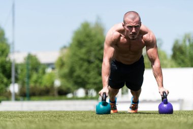 Kettle Bell ile şınav çeken sağlıklı bir sporcu - Kettle-Bell Egzersizi