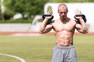 Kettle Bell 'le antrenman yapan adam vücut geliştirici. Kettle Bell' le ağırlık egzersizi yapıyor.