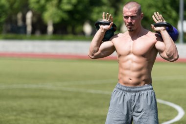 Kettle Bell 'le antrenman yapan adam vücut geliştirici. Kettle Bell' le ağırlık egzersizi yapıyor.
