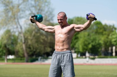 Kettle Bell 'le antrenman yapan adam vücut geliştirici. Kettle Bell' le ağırlık egzersizi yapıyor.