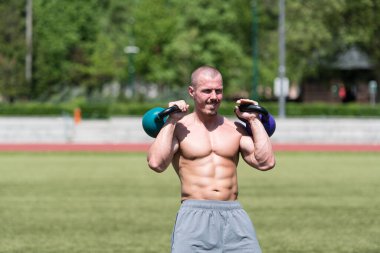 Kettle Bell 'le antrenman yapan adam vücut geliştirici. Kettle Bell' le ağırlık egzersizi yapıyor.