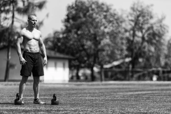 Mężczyzna Ćwiczy Kettle Bell Zewnątrz Kulturysta Robi Ciężkie Ćwiczenia Kettle — Zdjęcie stockowe