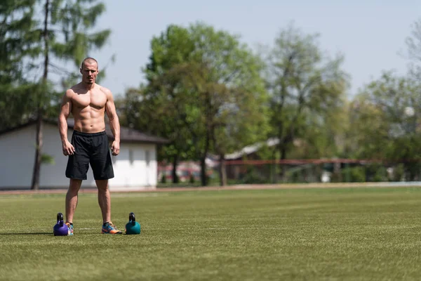 Mężczyzna Ćwiczy Kettle Bell Zewnątrz Kulturysta Robi Ciężkie Ćwiczenia Kettle — Zdjęcie stockowe